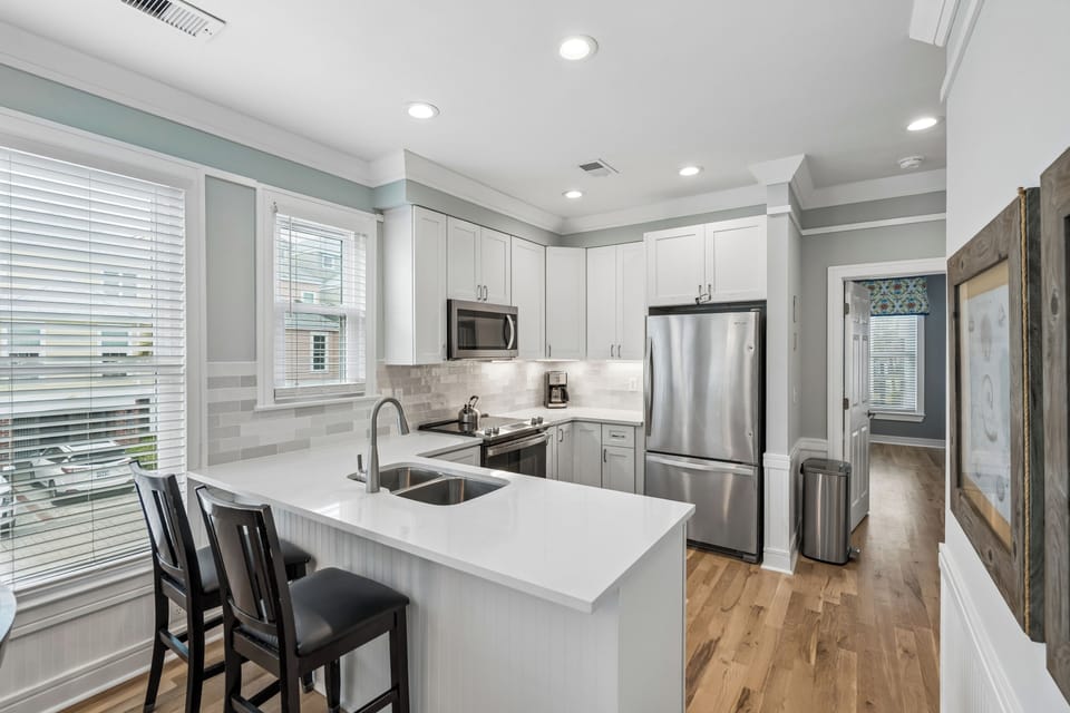 Your fully equipped kitchen awaits with sleek quartz countertops, stainless appliances, and a breakfast bar where you can sip morning coffee.