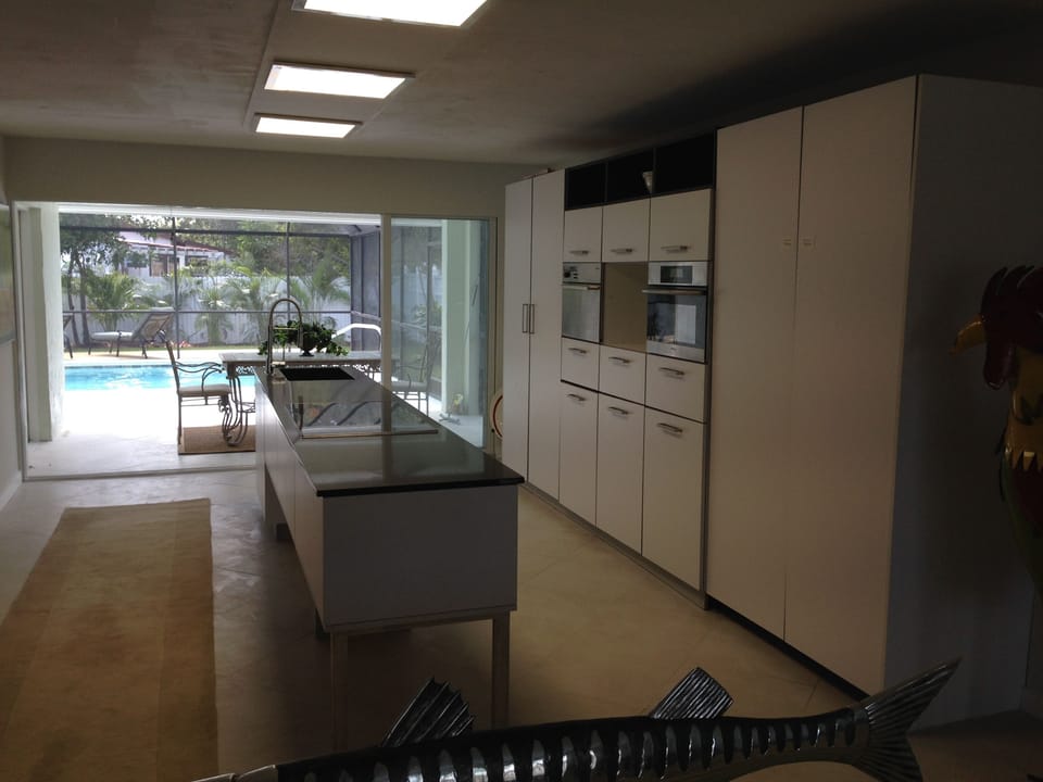 Kitchen and covered lanai become one with sliders full open.