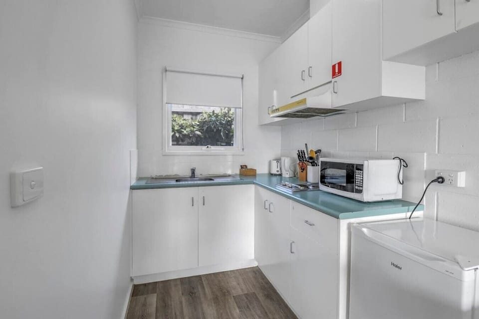 Compact kitchenette with fridge, microwave and essentials for easy self-catering stays.