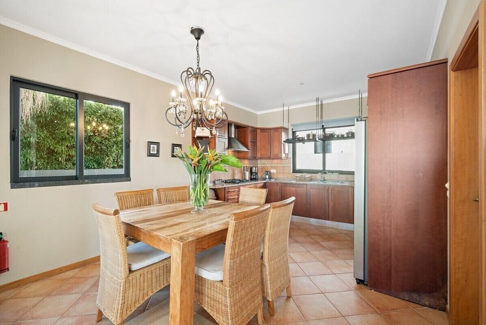 The dining table and kitchen invite shared culinary moments with family and friends.