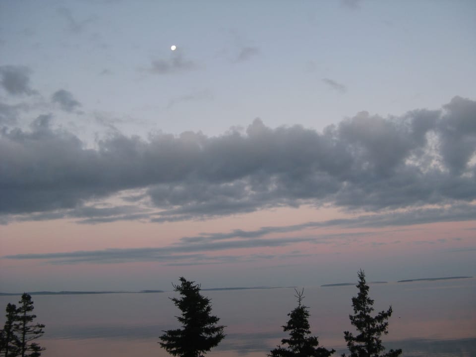 Moon set in front of cottage