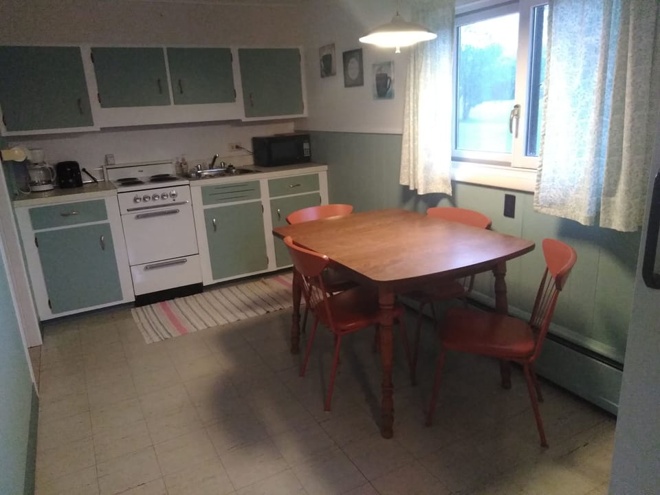 kitchen with refrigerator, small stove, microwave, toaster, coffee pot