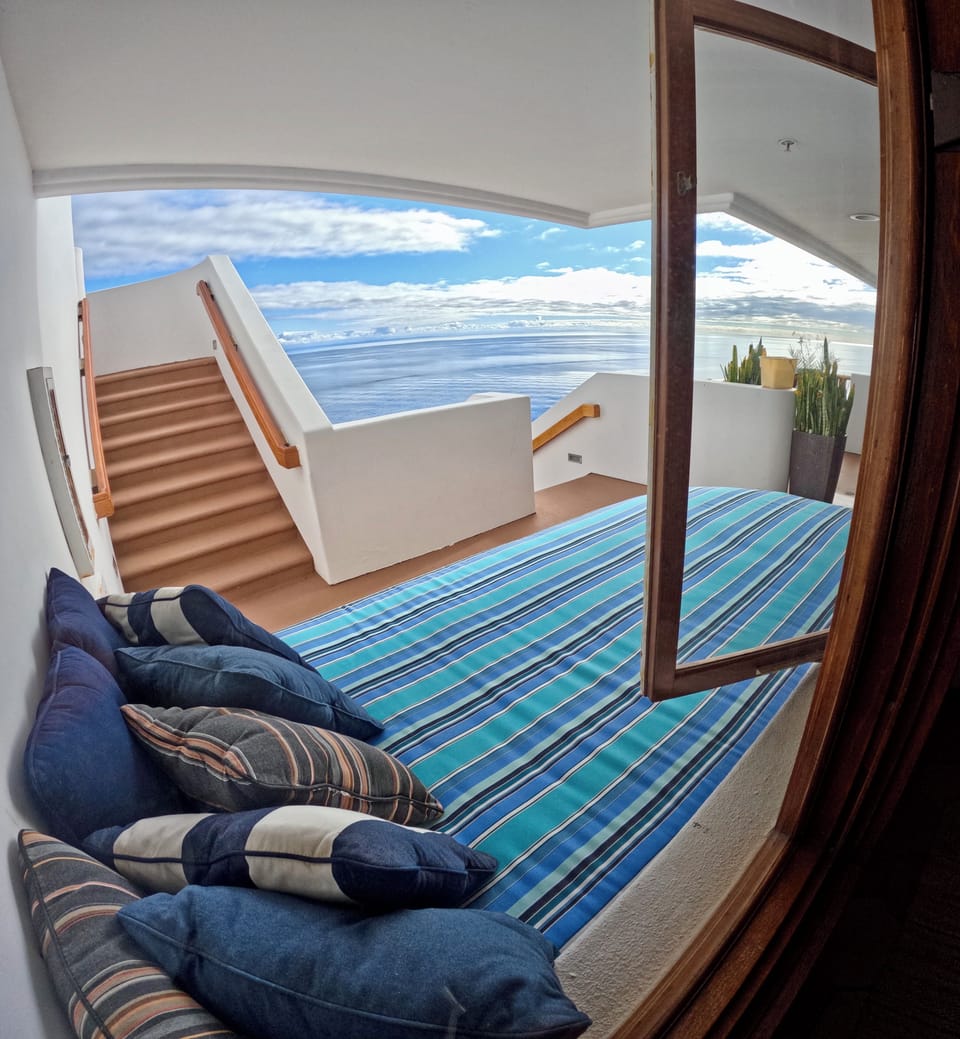 - Recline on a striped daybed with cozy pillows, just steps from your private stairway to the sea
- Floor to ceiling views flood in through open windows for a breezy, indoor outdoor feel
- Serene nook perfect for afternoon naps or reading