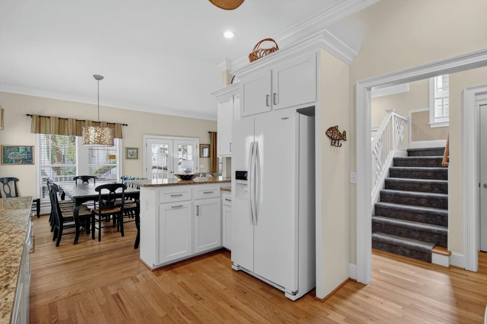 Step into your bright, open kitchen with gleaming hardwood floors, white cabinetry, and modern appliances. The adjoining dining area and welcoming layout invite you to cook, gather, and make yourself at home.