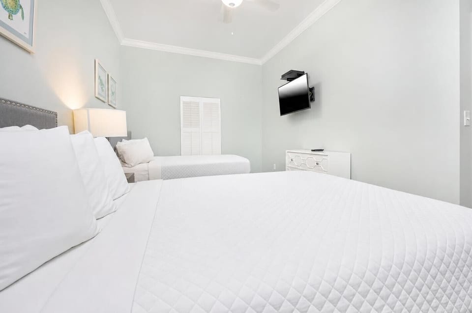 Relax in this guest bedroom featuring two queen beds and a wall-mounted TV for entertainment
