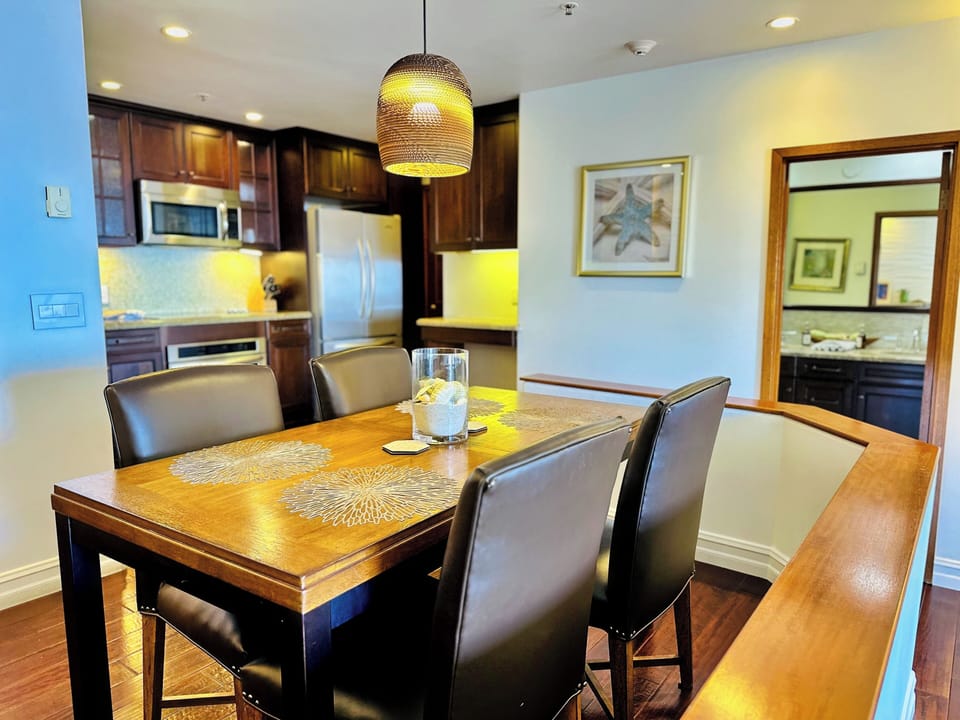 - Enjoy meals at a stylish wood dining table set beneath a warm, woven pendant light
- Fully equipped kitchen with stainless appliances and rich cabinetry for easy cooking
- Open layout with cozy ambiance, perfect for group gatherings