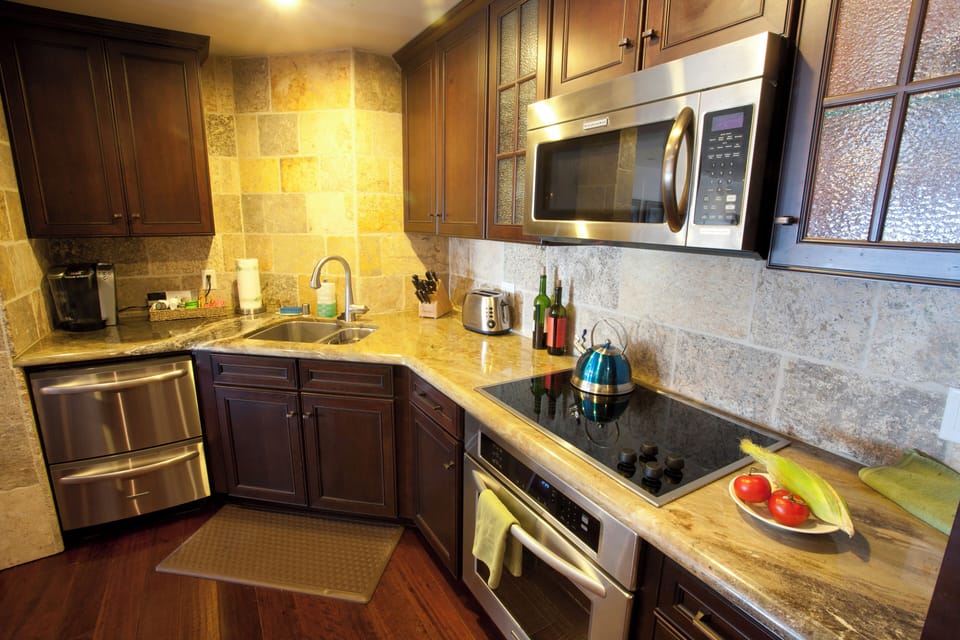 - Fully stocked kitchen, featuring sleek stainless appliances and a smooth electric cooktop
- Enjoy a touch of rustic charm with natural stone backsplash and rich wood cabinetry
- Includes a Keurig, toaster, and all essentials to fuel your adventures