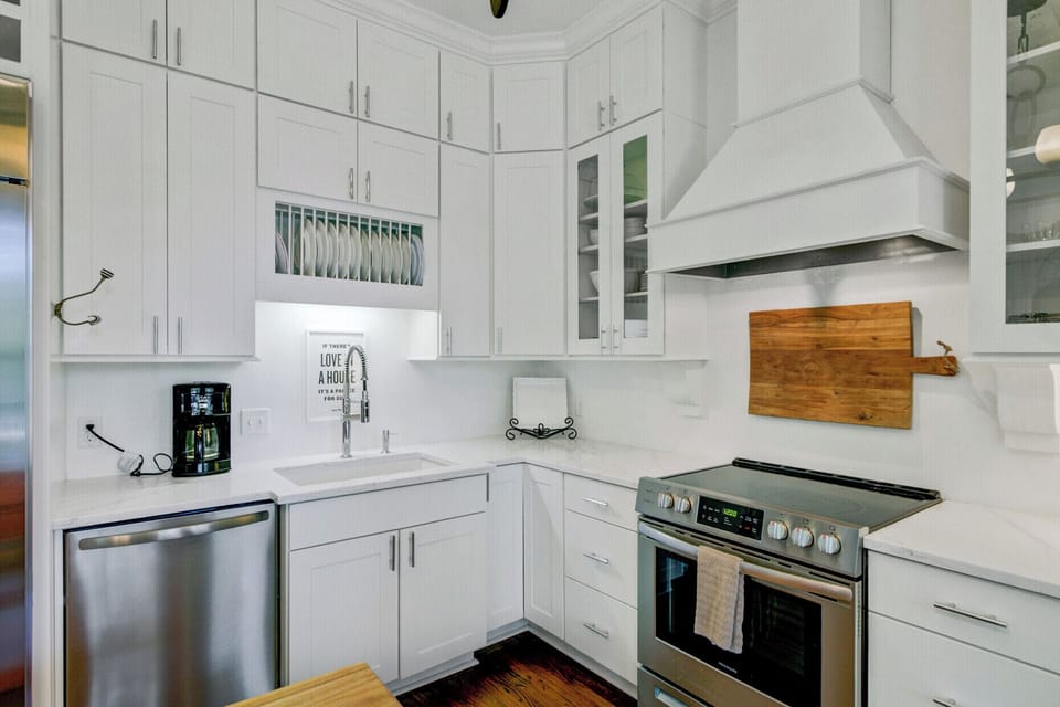 Your bright, fully-equipped kitchen features gleaming white cabinets, stainless steel appliances, and thoughtful touches that make cooking feel like home.