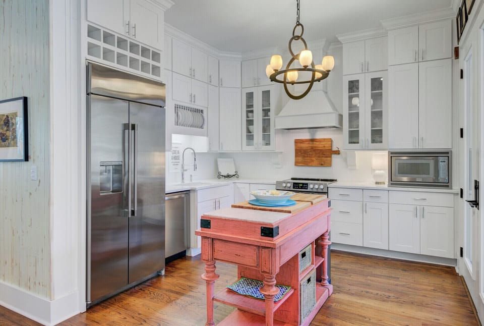 Your charming kitchen features crisp white cabinets and a delightful coral island where you'll love preparing meals together.