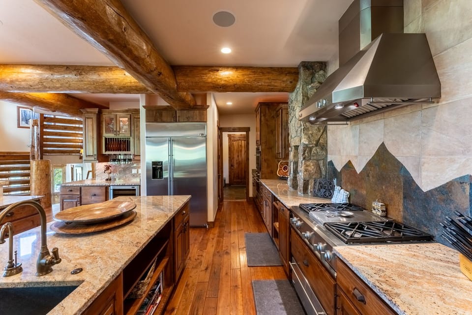 Your mountain-inspired chef's kitchen features granite counters, exposed beam ceilings, and professional-grade appliances perfect for creating memorable meals.