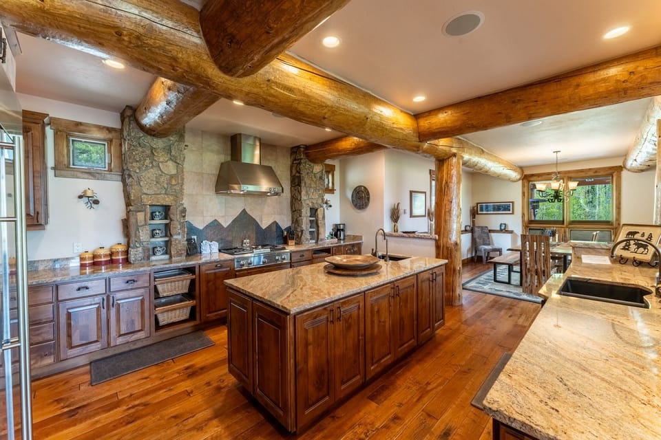 This stunning rustic kitchen with exposed beams and granite island invites you to create memorable meals in mountain elegance.