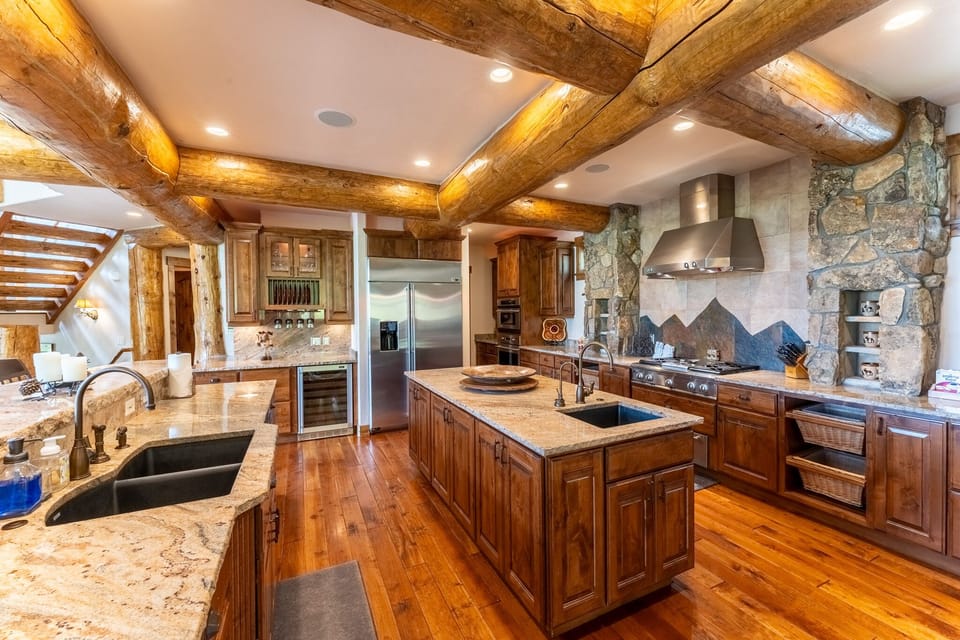 Your gourmet kitchen blends rustic charm with modern luxury—granite counters, stainless appliances, and dramatic exposed beams create the perfect culinary sanctuary.