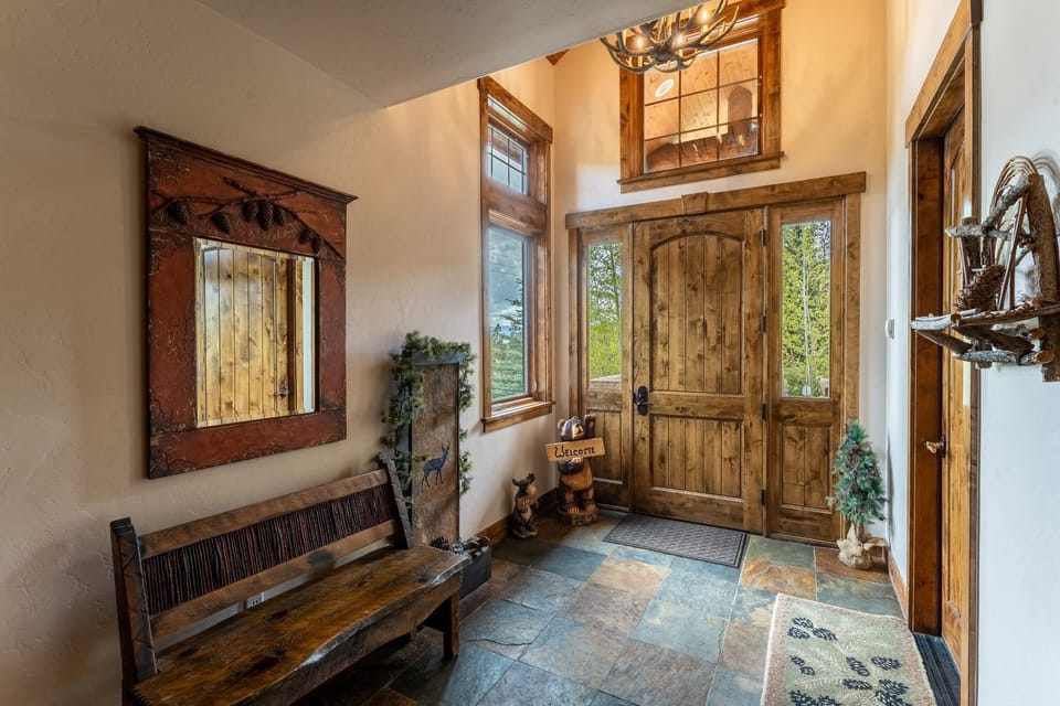 Step into your mountain retreat through this stunning rustic entrance with handcrafted wooden details and cozy seating that welcomes you home.
