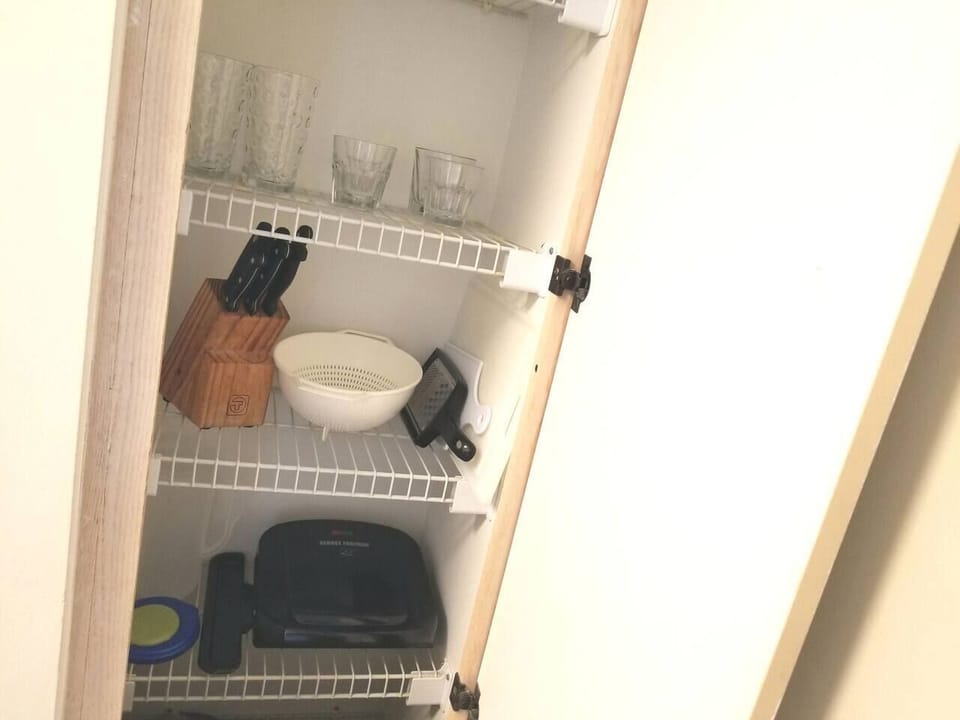 Kitchen has complete place settings and cooking utensils 