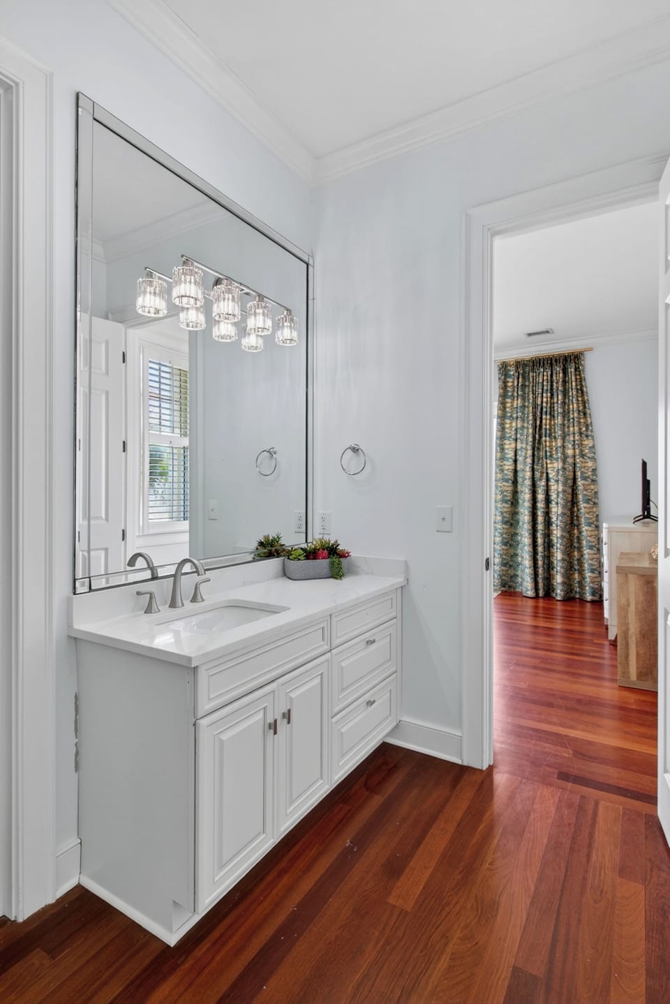 Refresh in your elegant bathroom with gleaming fixtures, beautiful lighting, and rich hardwood floors beneath your feet.