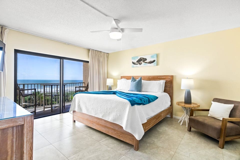 Spacious king master bedroom with a private balcony and ocean breeze.