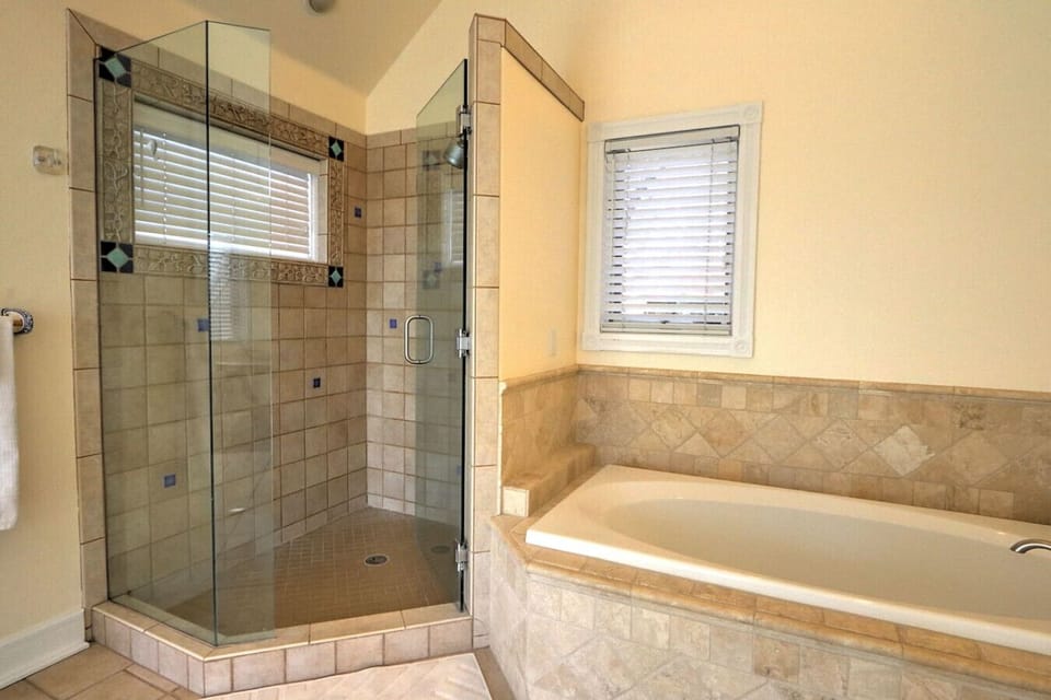 Primary bathroom with tub and glass enclosed shower