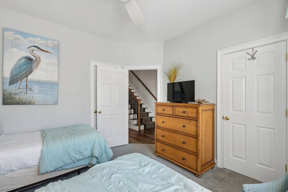 Sink into plush beds dressed in calming coastal tones and wake refreshed in this serene, light-filled bedroom. Your wardrobe and entertainment are close at hand.