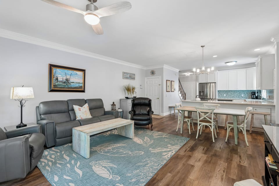 Unwind in your bright, open-concept space where coastal charm meets comfort. Gather around the dining table or sink into plush seating—everything you need for a relaxing getaway.