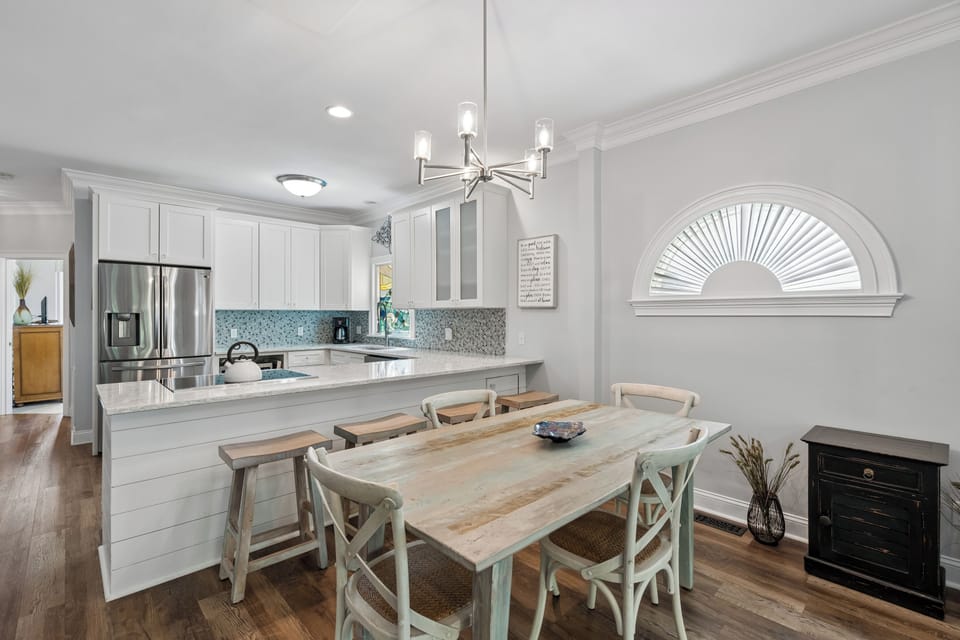 Your bright, fully equipped kitchen flows into a charming dining space with farmhouse-style seating, perfect for sharing meals and making memories together.