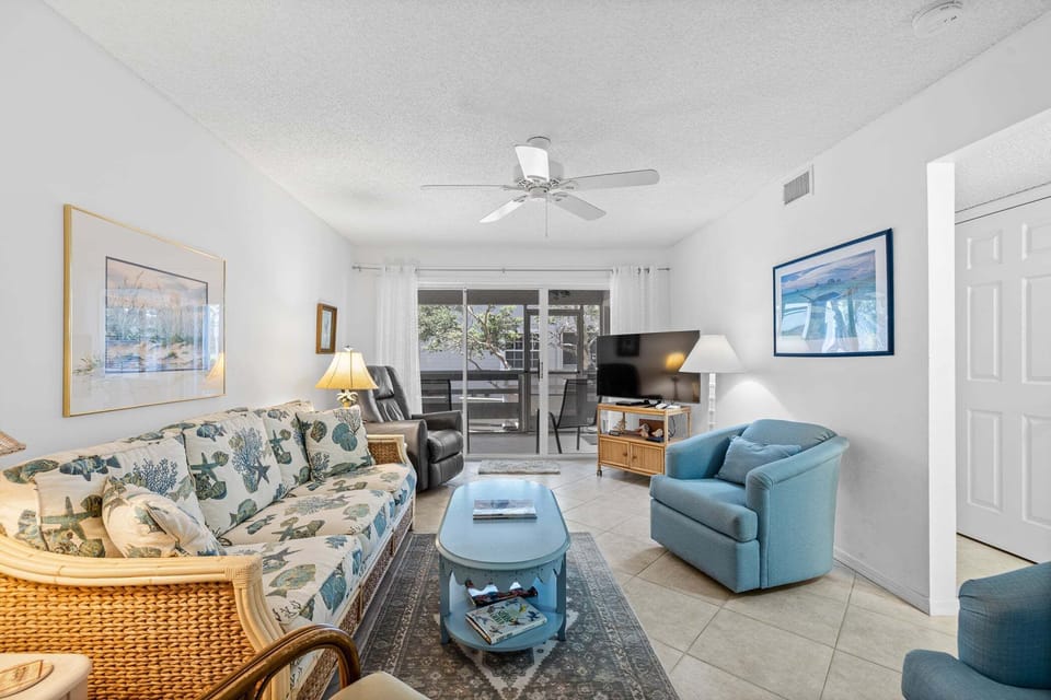 Inviting living room with comfortable seating, coastal décor, and private balcony access