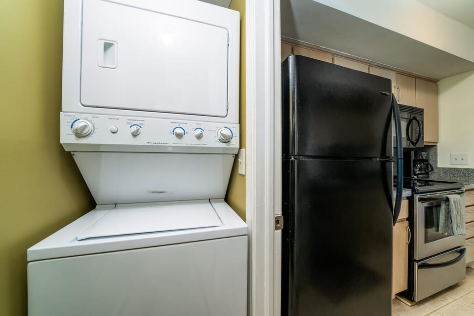 Laundry sits just outside the kitchen. You have a stacked washer and dryer to use.