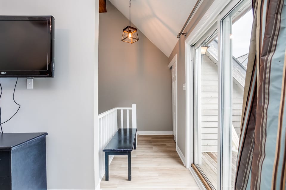 Hallway into the second floor loft bedroom. Door to the upstairs deck. 
