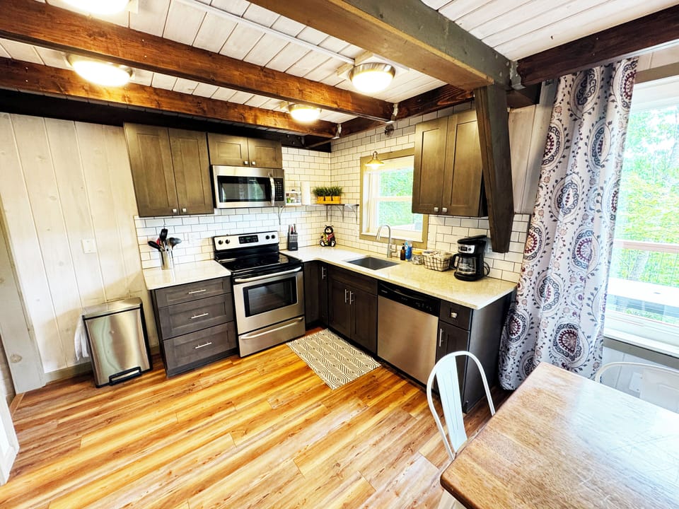 Full kitchen with pots, pans and drip coffee maker. 