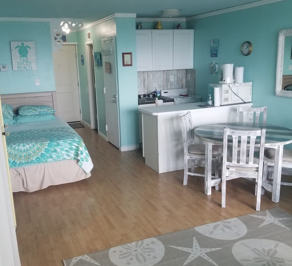 Queen bed by kitchen and dining table