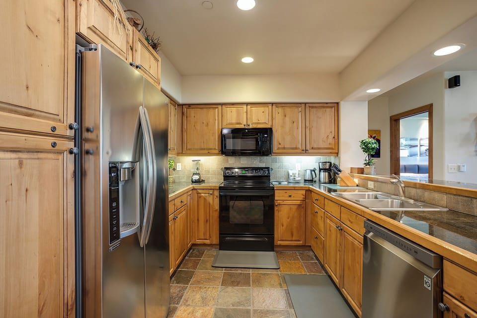 Your fully equipped kitchen features warm wood cabinetry, stainless steel appliances, and granite countertops—perfect for preparing memorable meals during your stay.
