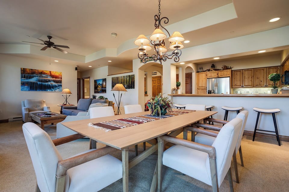 Gather around your elegant dining table where every meal becomes memorable, with warm lighting and an open kitchen perfect for entertaining.