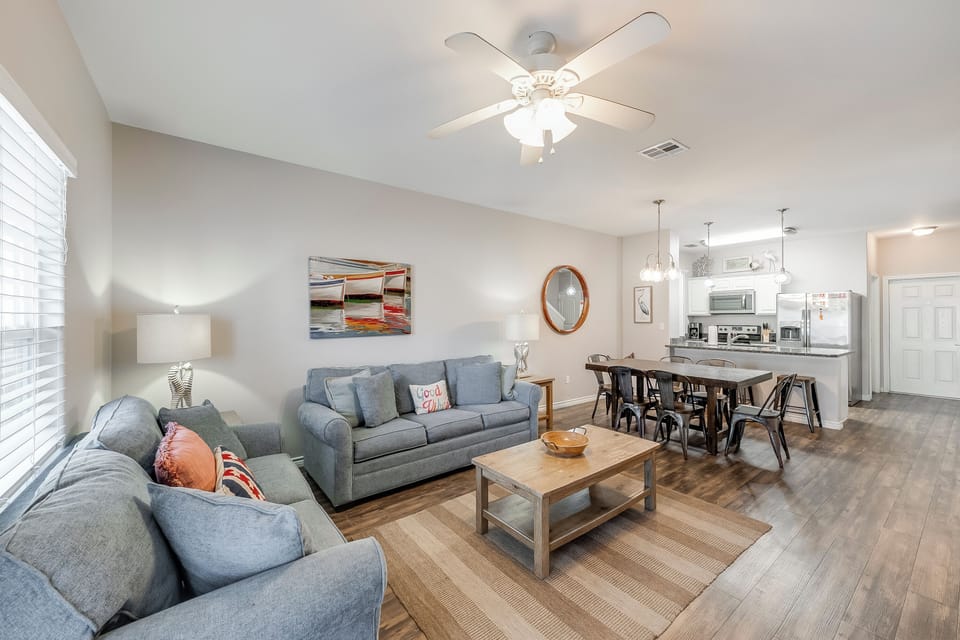 Relax in your spacious open-concept retreat with plush gray seating and beautiful wood-look floors flowing into the modern kitchen.