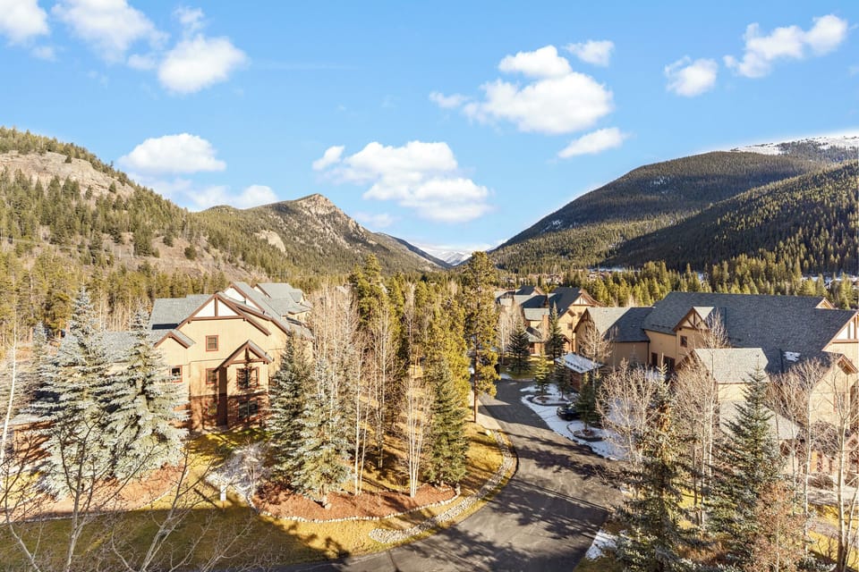 Mountain resort community nestled in a pristine alpine valley with snow-capped peaks and forested slopes creating a stunning natural backdrop.