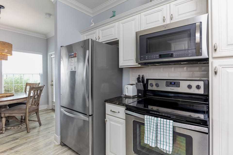 Your fully equipped kitchen awaits with stainless steel appliances, granite counters, and crisp white cabinetry for memorable meal preparation.
