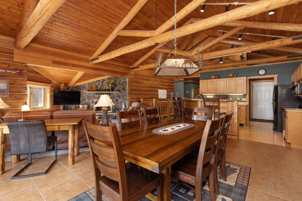 Dining area with views to the kitchen and main level fireplace and living room.