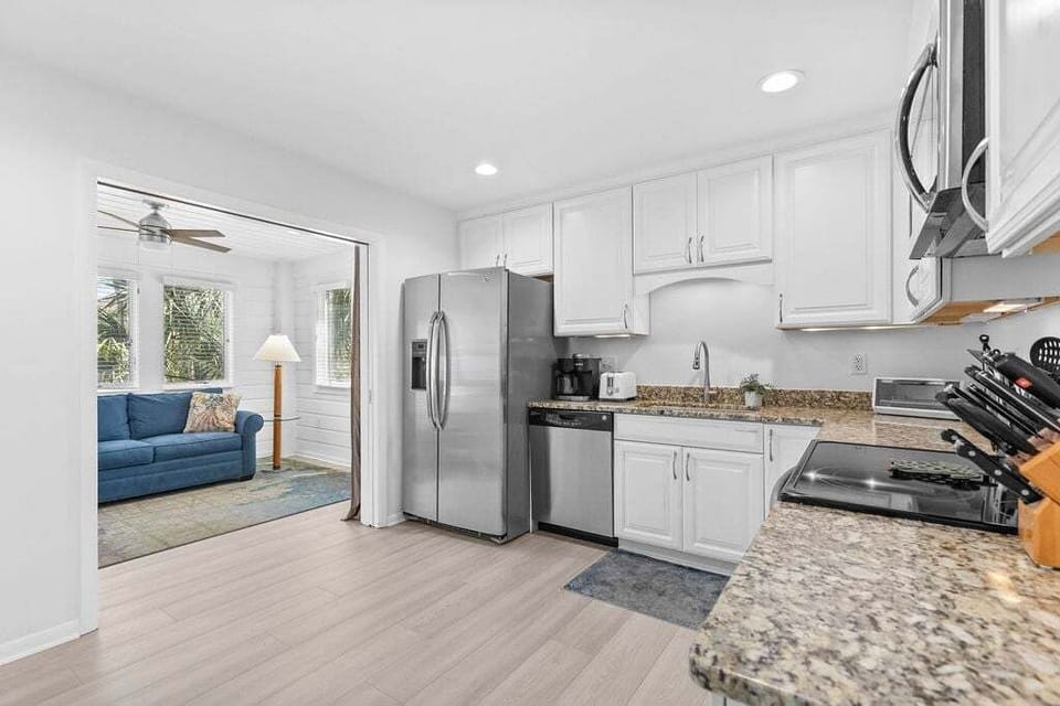 Large, remodeled kitchen with stainless steel appliances, granite countertops.