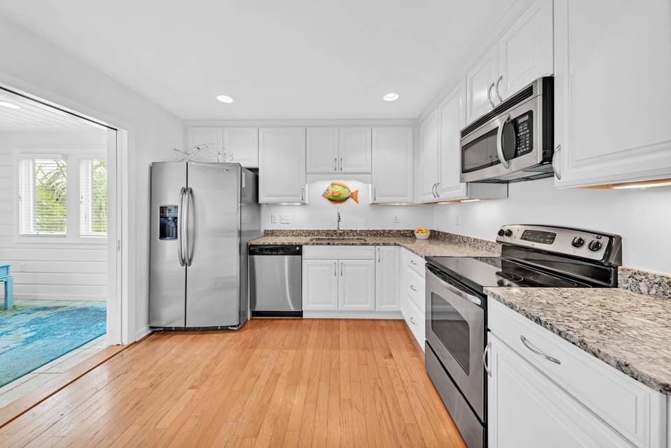 Large, remodeled kitchen with stainless steel appliances, granite countertops.