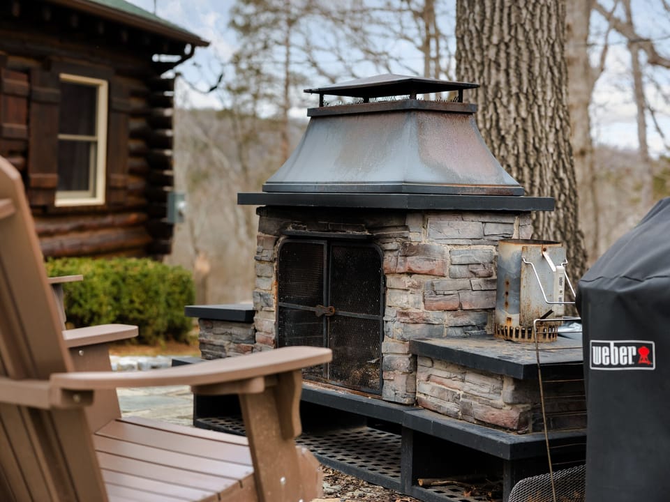 patio area with chairs, charcoal grill and wood fireplace
