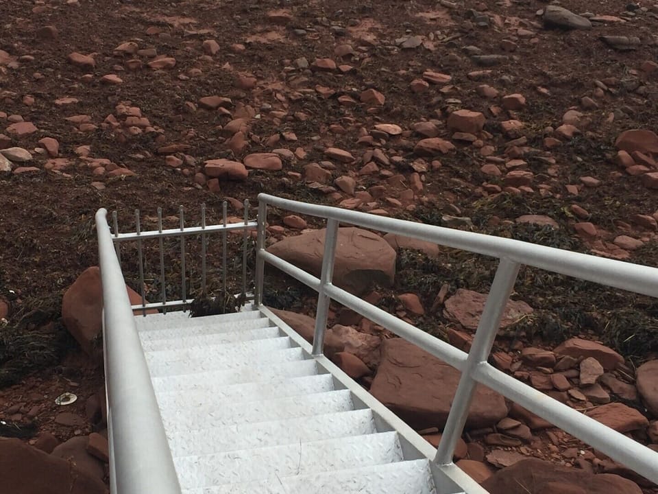 Stairs on front lawn down to the beach/ocean.