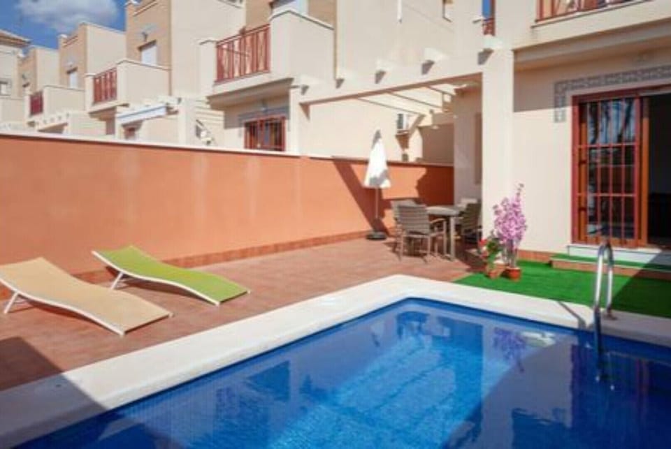 The front view of the villa with private swimming pool, seating area + loungers