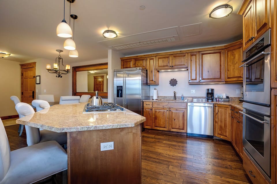 Your gourmet kitchen features granite countertops, stainless steel appliances, and a spacious island perfect for preparing meals and gathering together.