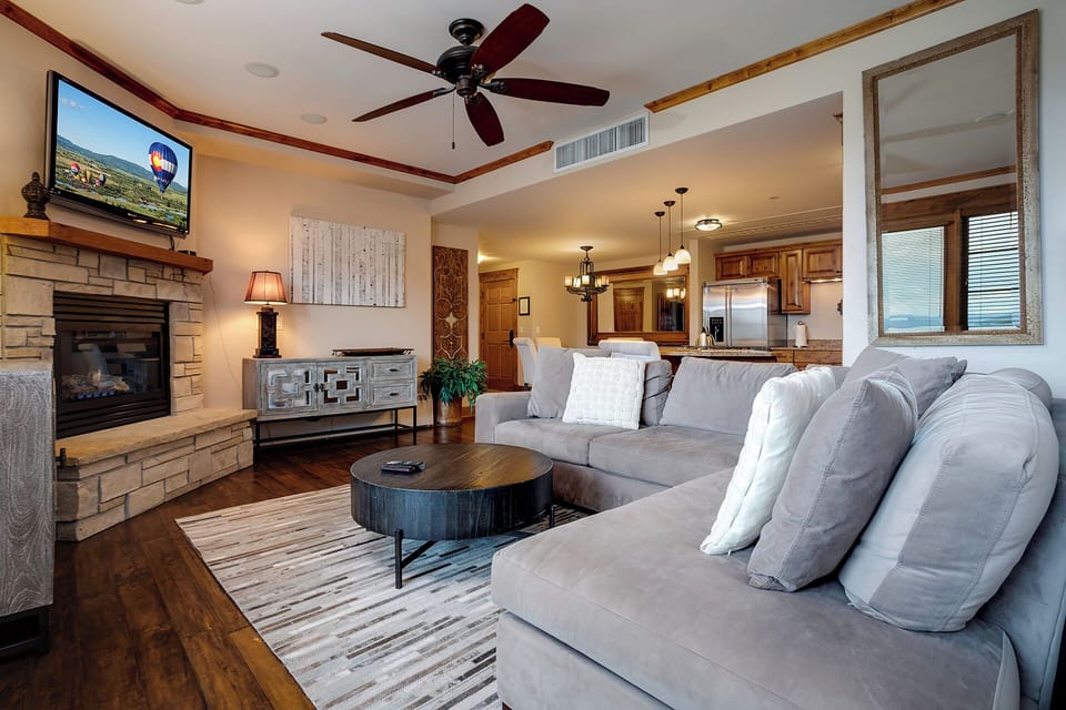 Sink into plush seating by your crackling fireplace, where warm wood tones and modern comfort create the perfect retreat for cozy evenings together.