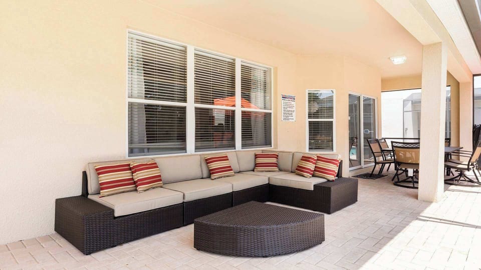 Relax in this spacious covered patio with cozy seating, dining area, and pool access.