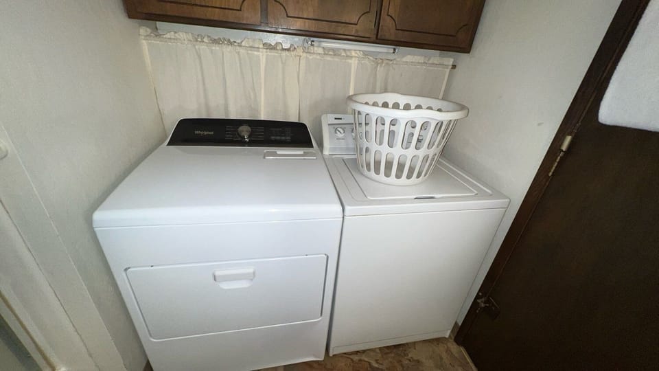 Laundry nook with a washer, dryer and wall cabinets.
