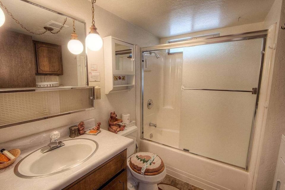 Bathroom with a bathtub, shower door and vanity.