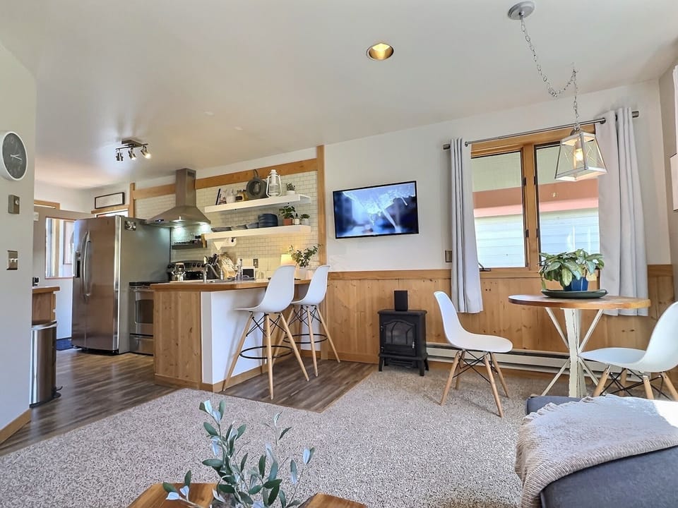 Sleek Social Kitchen — Stainless appliances, a fully stocked setup, and a bar top made for chatting while dinner simmers—easy, warm, and inviting. 🍽️🥂