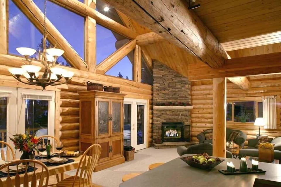 Cozy log cabin family room with vaulted ceilings and stone fireplace