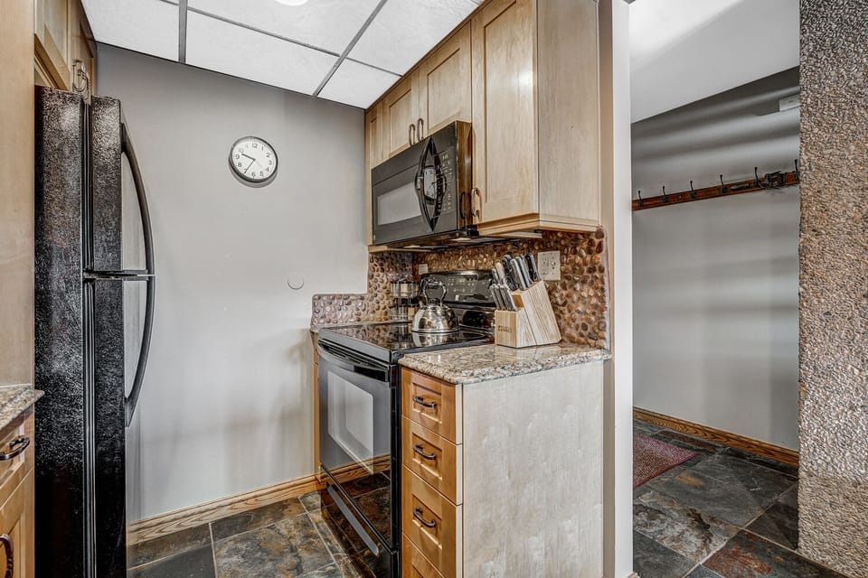 Kitchen Area - stove top oven, microwave, refrigerator along with spice rack
