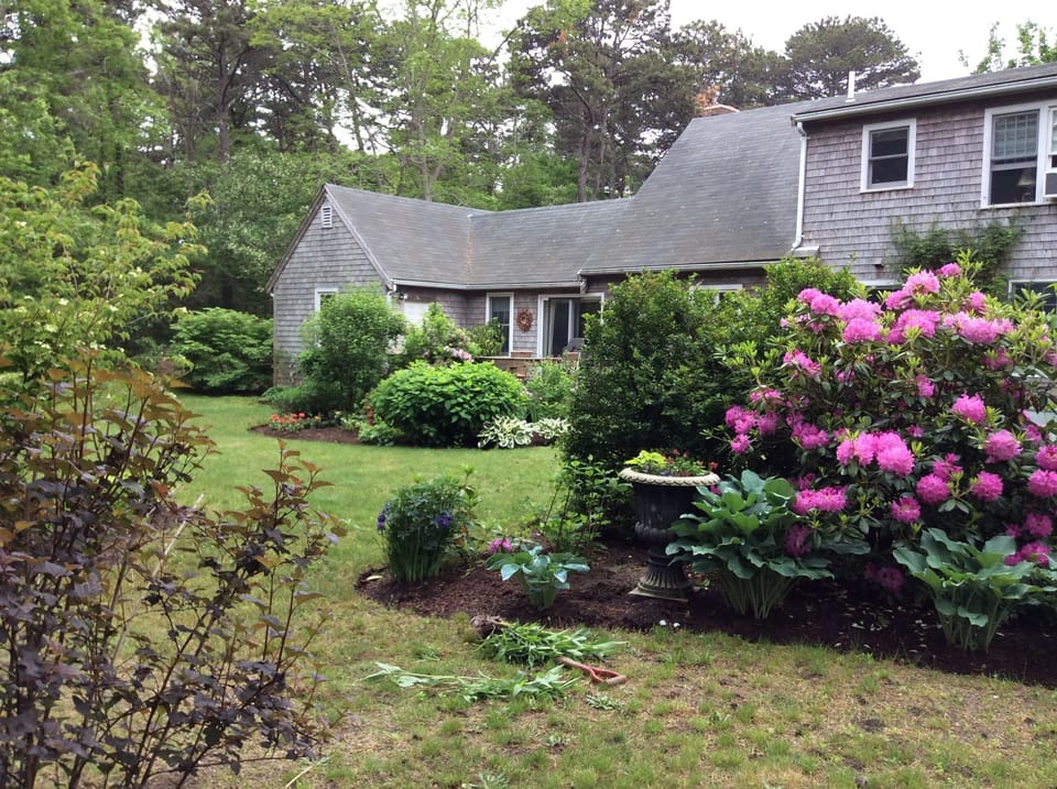 Beautifully landscaped gardens with deck barbecue grill and fire pit