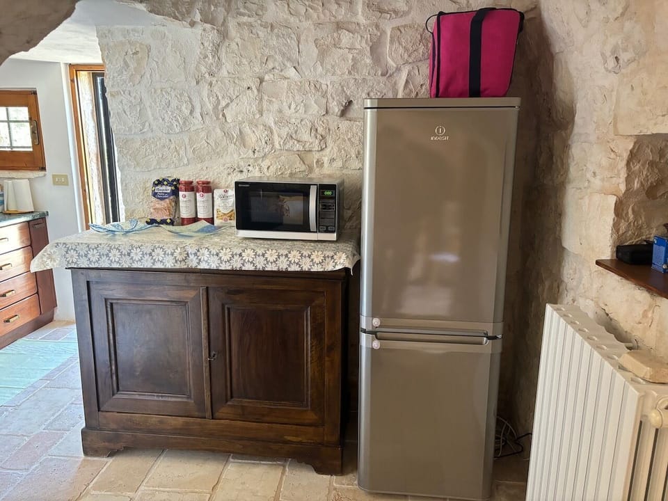 Fridge and credenza storing crockery and pots and pans.